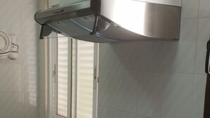 A kitchen with a stainless steel range hood, a built-in oven, a sink, and a window with blinds. - GEMELOS 12(2 BEDROOMS) (Benidorm)
