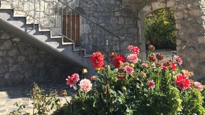 Ein Steinhaus mit einer Treppe, die zu einer Holztür führt.