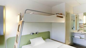 A bunk bed with a green headboard, a bedside table, and a mirror above the sink.