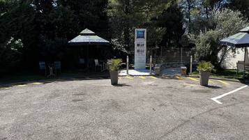 Un estacionamiento con un cartel que muestra los precios para distintos días.