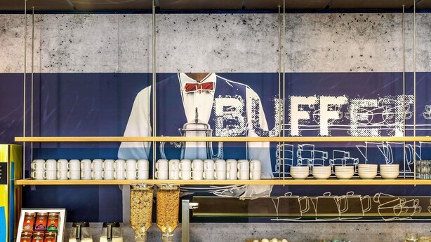 Ein Buffet mit einer großen Beschilderung, verschiedenen Servierstationen und einer Auswahl an Speisen.