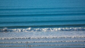 Une vue sur la côte, avec une mer calme et de douces vagues.