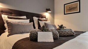 Ein ordentlich bezogenes Bett mit Kopfteil, Kissen und einem dekorativen Kissen mit einer Notiz.