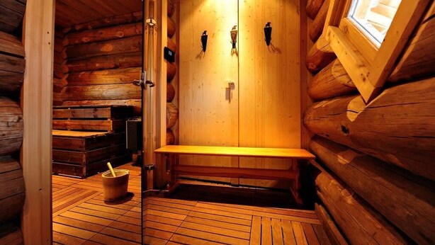 Een sauna met houten wanden en een bank.