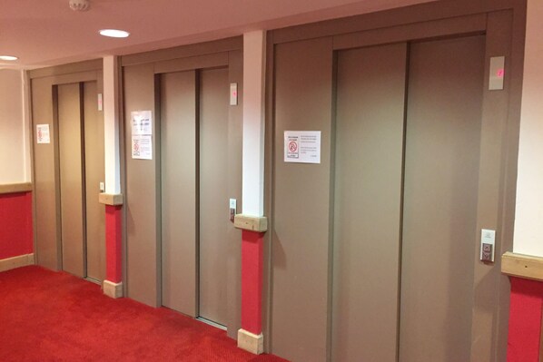 Varias puertas cerradas con letreros de ‘prohibido el paso’ y un detector de incendios.