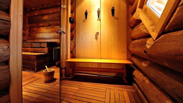 A sauna room with wooden walls, a bench, and a bucket. - Risoul - Apart 202 - Pool/Sauna - WIFI - Fully equipped - Foot of slopes (Risoul)