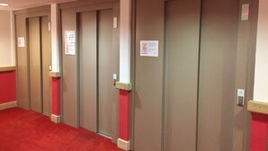 A row of closed elevator doors in a hallway with red carpet flooring. - Risoul - Apart 202 - Pool/Sauna - WIFI - Fully equipped - Foot of slopes (Risoul)