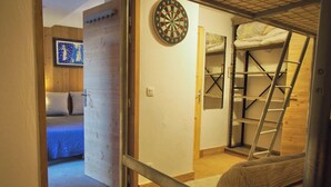 Un dormitorio con una cama, un dardo y una escalera.