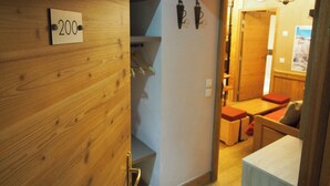 Un intérieur en bois avec une enseigne portant le chiffre « 200 », un escalier et un coin salon avec des coussins.