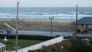 Vista costera con un muelle, una playa y un edificio con techo.
