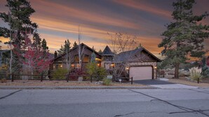 Eine Blockhütte mit Garage, umgeben von Bäumen und einer Auffahrt.