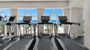 A gym with treadmills and exercise bikes, large windows with a beach view. - Calypso 19th Floor Beachfront - Walk to Pier Park - 2 Beachfront Pools (Panama City)