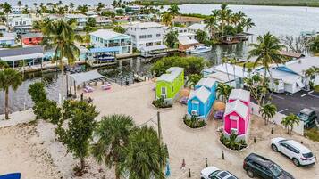 Uma área residencial costeira com casas coloridas, um porto de iates e uma praia arenosa.