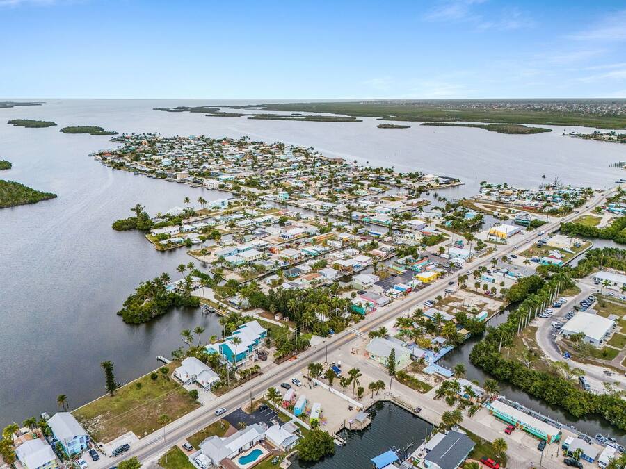Vista aérea de un pueblo costero con numerosos edificios, caminos y cuerpos de agua.