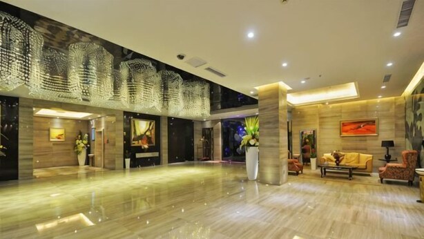 A spacious lobby with a polished marble floor, a reception desk, and a seating area with sofas and chairs. - Archos Boutique Hotel (Ankang)
