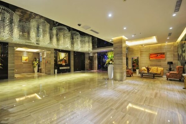 A spacious lobby with a polished marble floor, a reception desk, and a seating area with sofas and chairs. - Archos Boutique Hotel (Ankang)