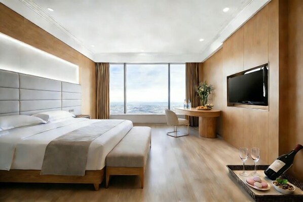 A modern hotel room with a large bed, a desk with a chair, a TV, and a city view. - Archos Boutique Hotel (Ankang)