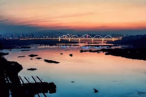 Un puente con múltiples arcos sobre un río tranquilo al atardecer.