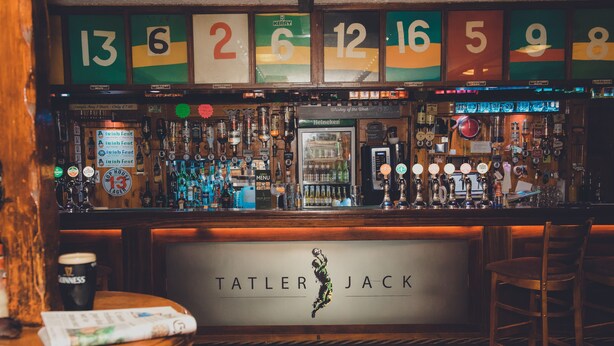 A bar with a checkered floor, a variety of beer taps, and a sign reading "TATLER JACK". - Tatler Jack (Killarney)