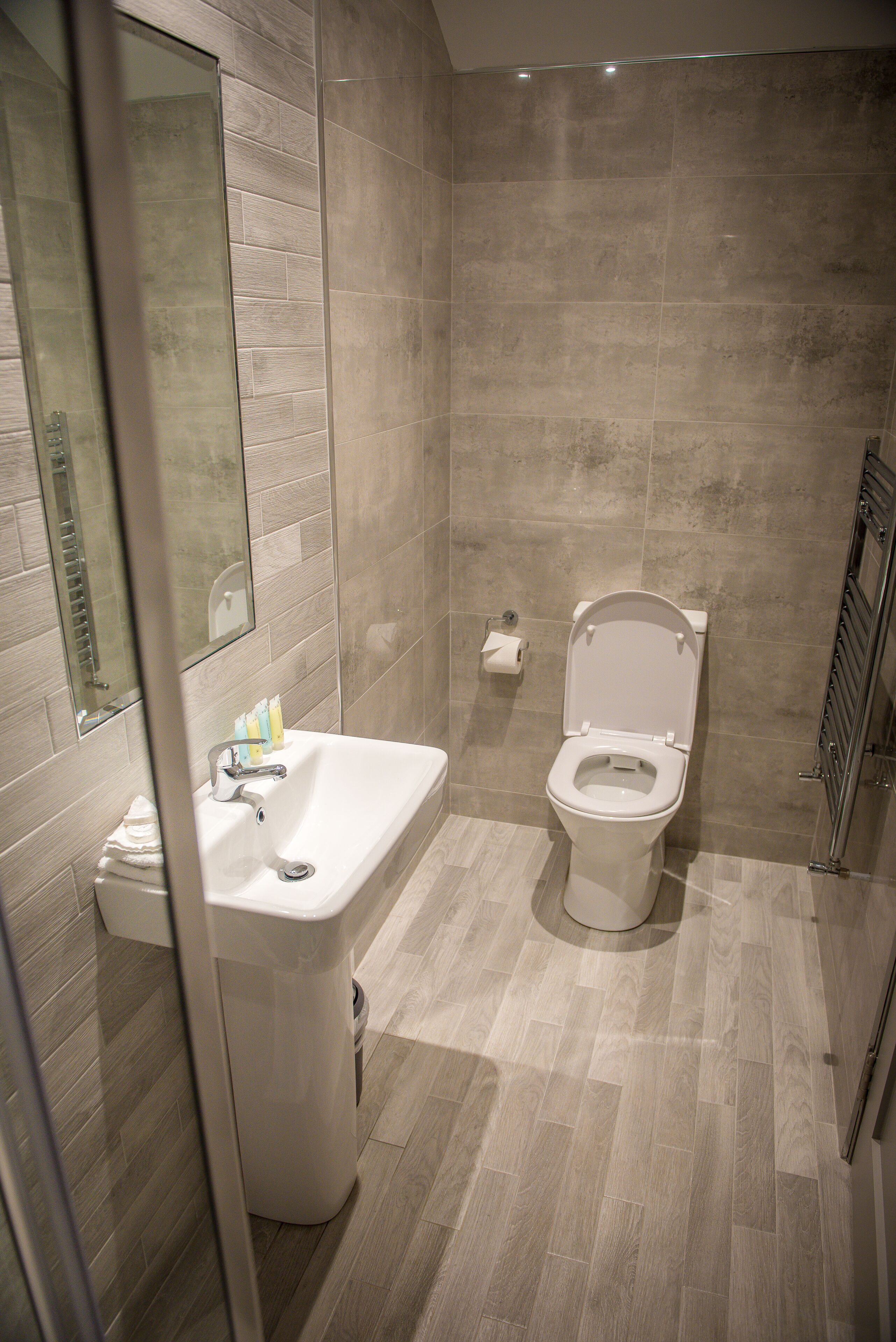 Un baño moderno con lavabo, inodoro y espejo.