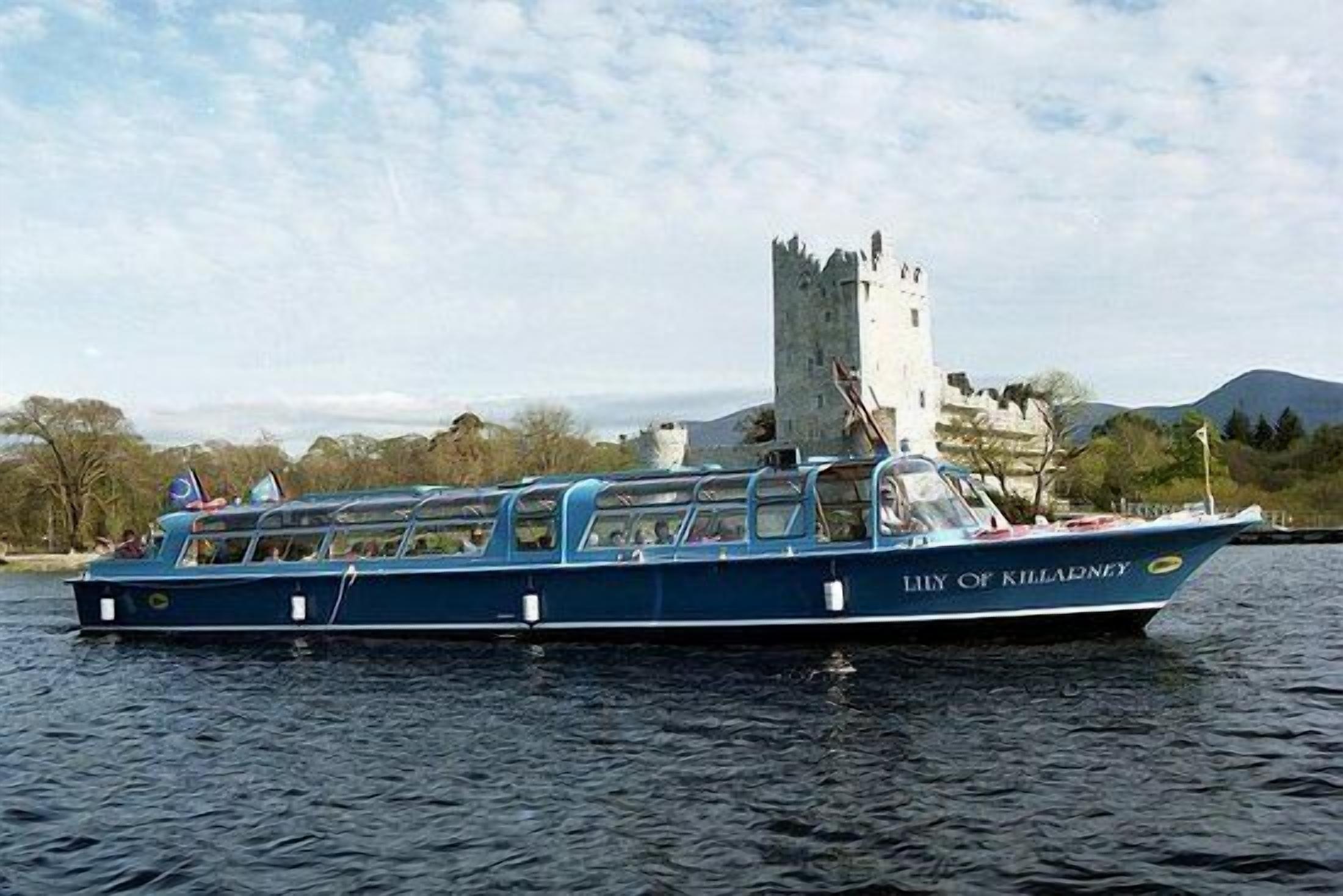 A boat named "Lily of Killareny" on water with a castle in the background.