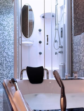 Une salle de bain moderne avec une douche à parois de verre, une chaise noire et une baignoire.