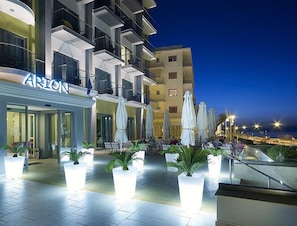 Een modern hotel met terras en plantenpotten.