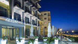 Un hôtel moderne doté d’une terrasse et de plantes en pot.