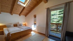 A bedroom with a wooden bed, a large window, and a view of the outdoors.