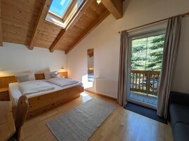 A bedroom with a wooden bed, a large window, and a view of the outdoors.