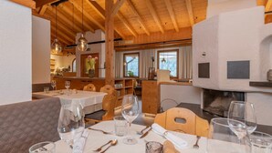 A restaurant with wooden interiors, tables set for dining, and a fireplace.