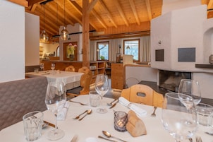 A restaurant with wooden interiors, tables set for dining, and a fireplace.