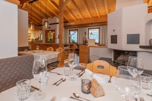 A restaurant with wooden interiors, tables set for dining, and a fireplace.