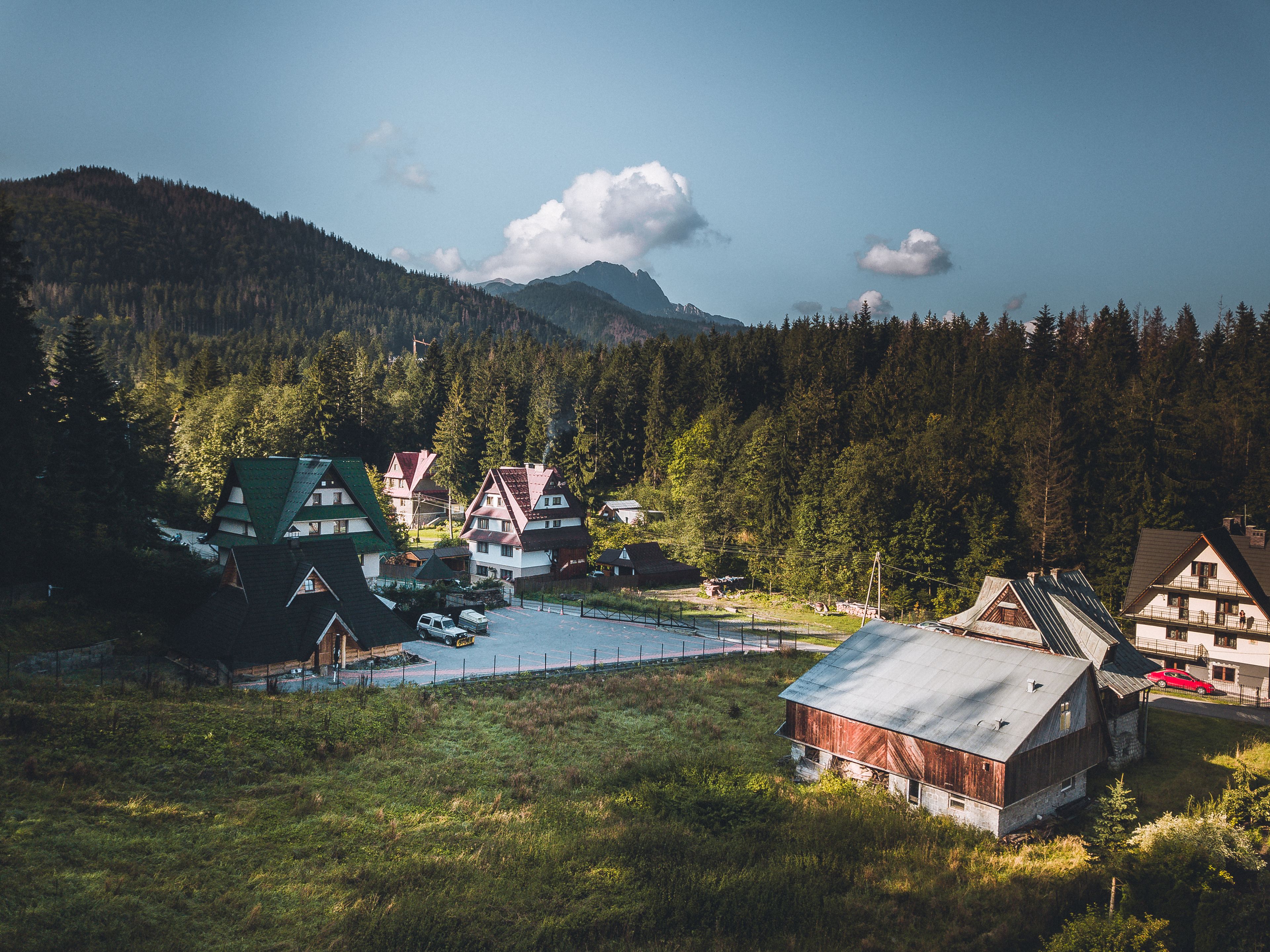 A mountain village with traditional houses, a swimming pool, and a barn.