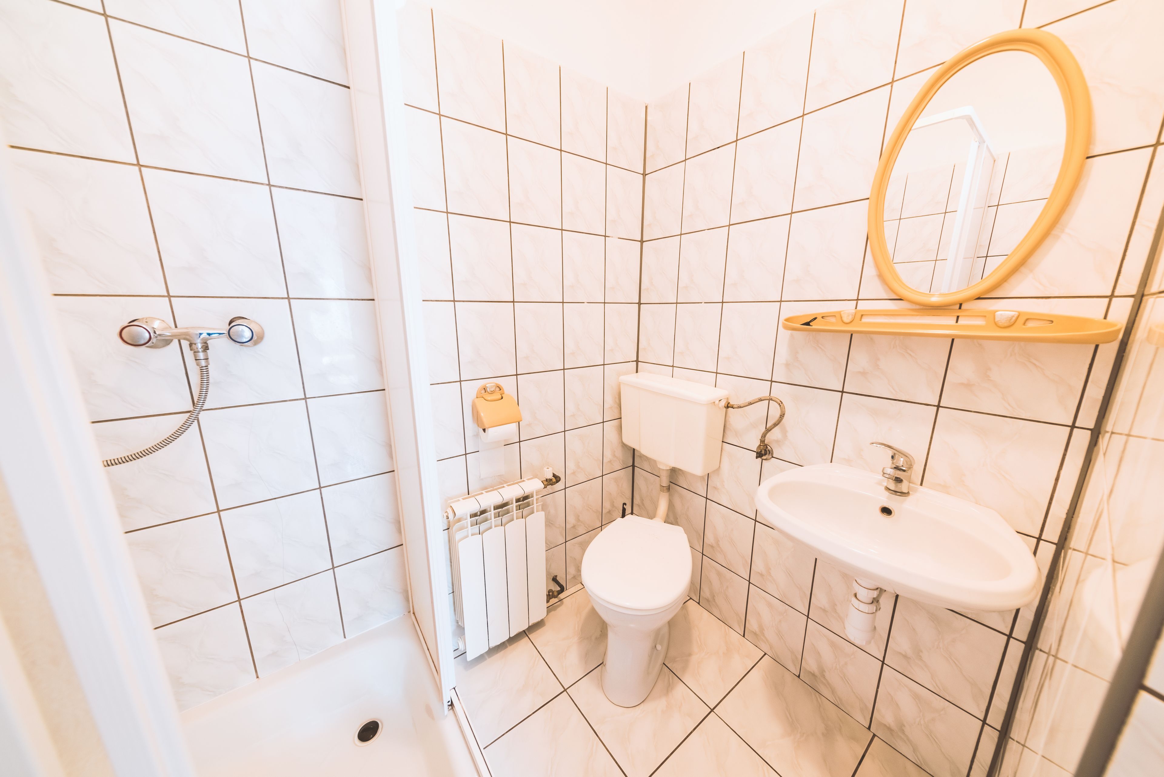 A bathroom with a toilet, sink, and shower.