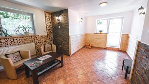 A cozy living room with a fireplace, a dining area, and a kitchen. - Hostel & Apartments u Florka 2 (Zakopane)