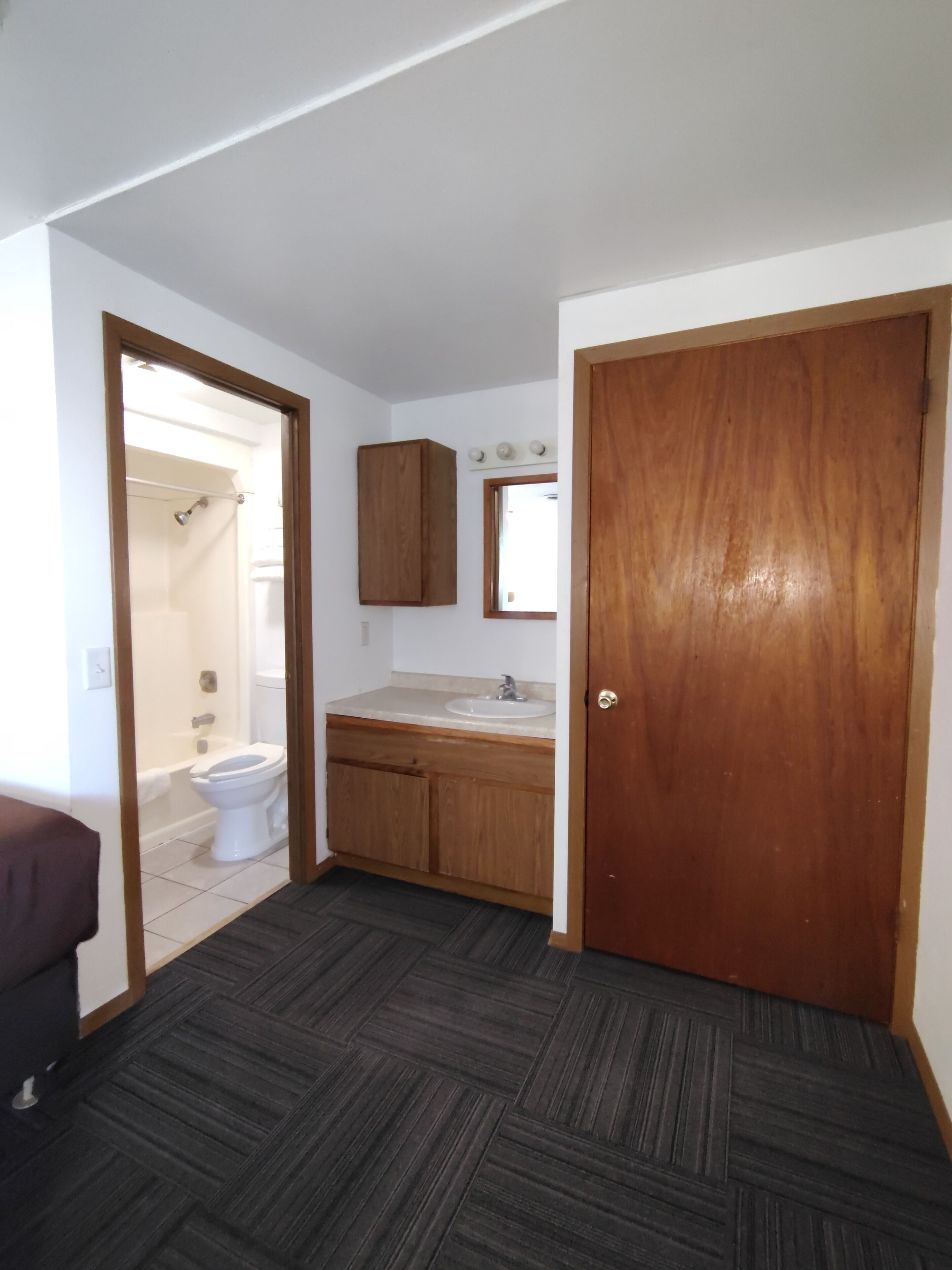 A bathroom with a toilet, sink, and shower.