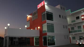 Vista frontal de la propiedad por la tarde o noche