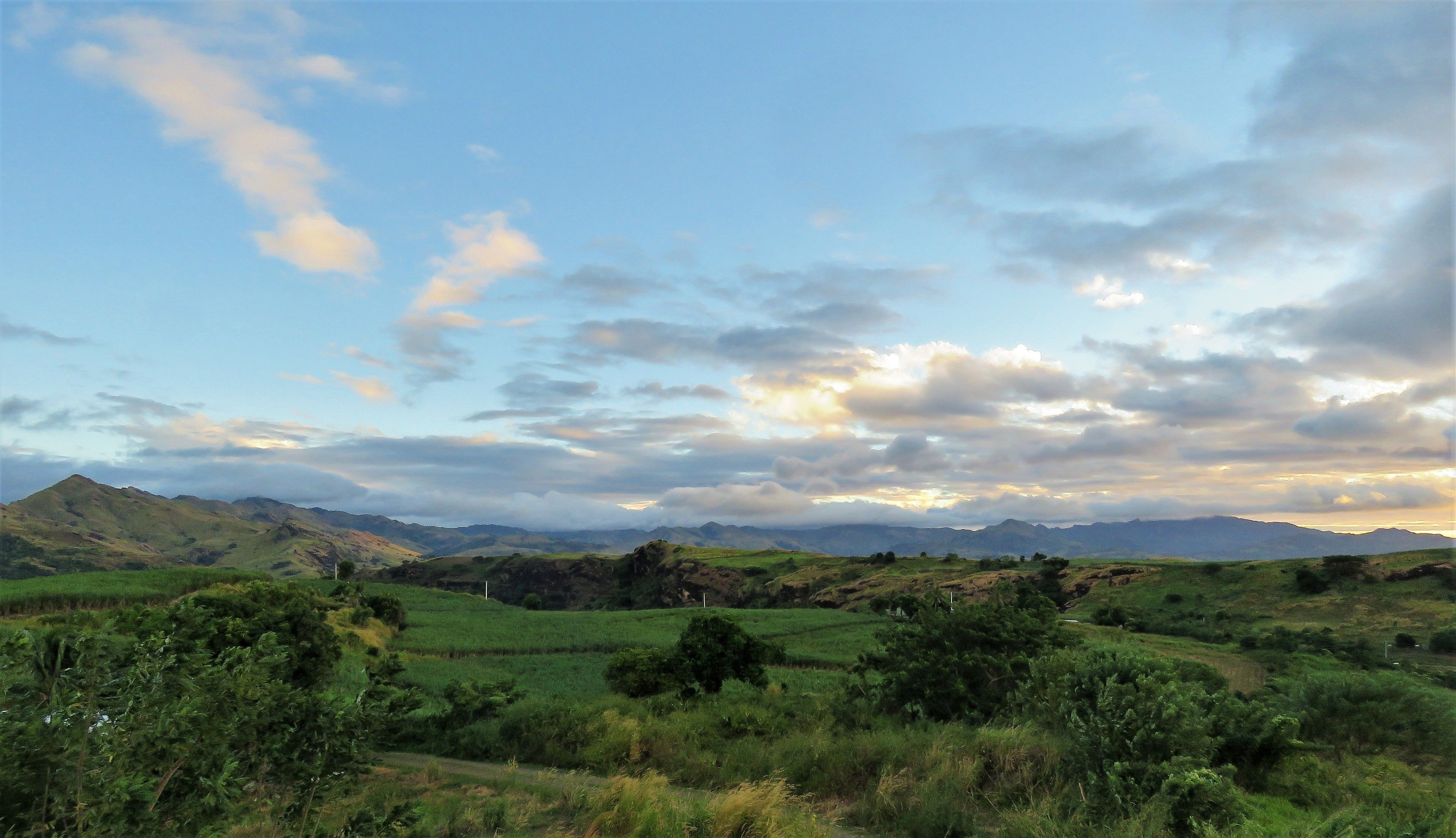 A panoramic view of a mountainous landscape with rolling green hills and a clear sky.
