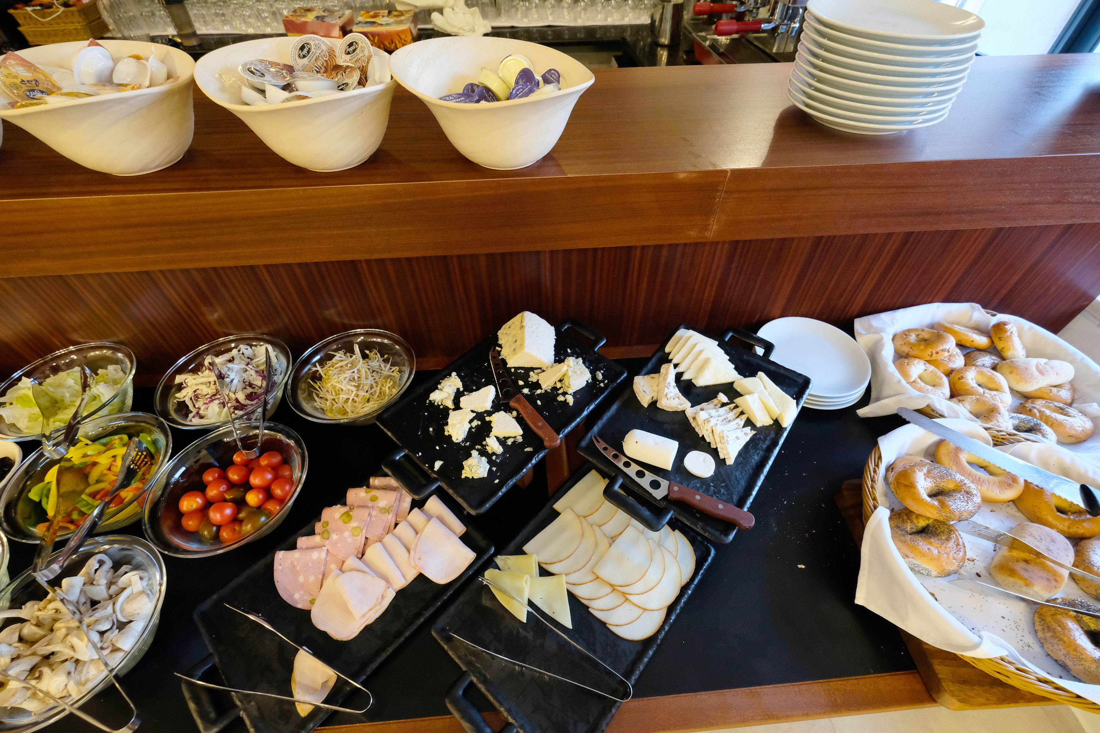 Buffet com diversas opções de comida, incluindo carnes, queijos e doces.