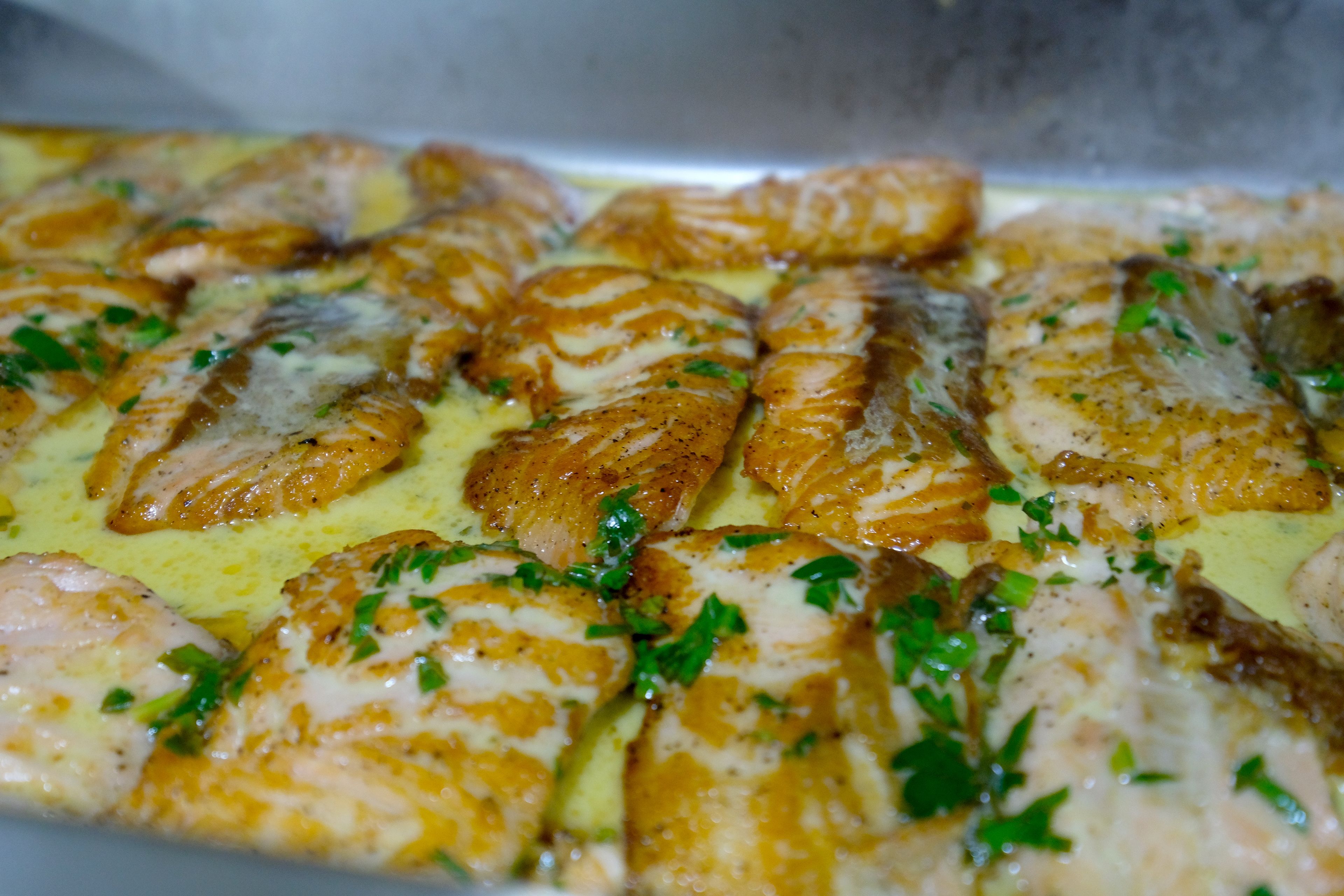 Een schaal gegrilde visfilets, versierd met kruiden.