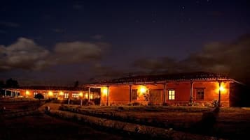 A building with multiple illuminated windows and a well-lit exterior at night.