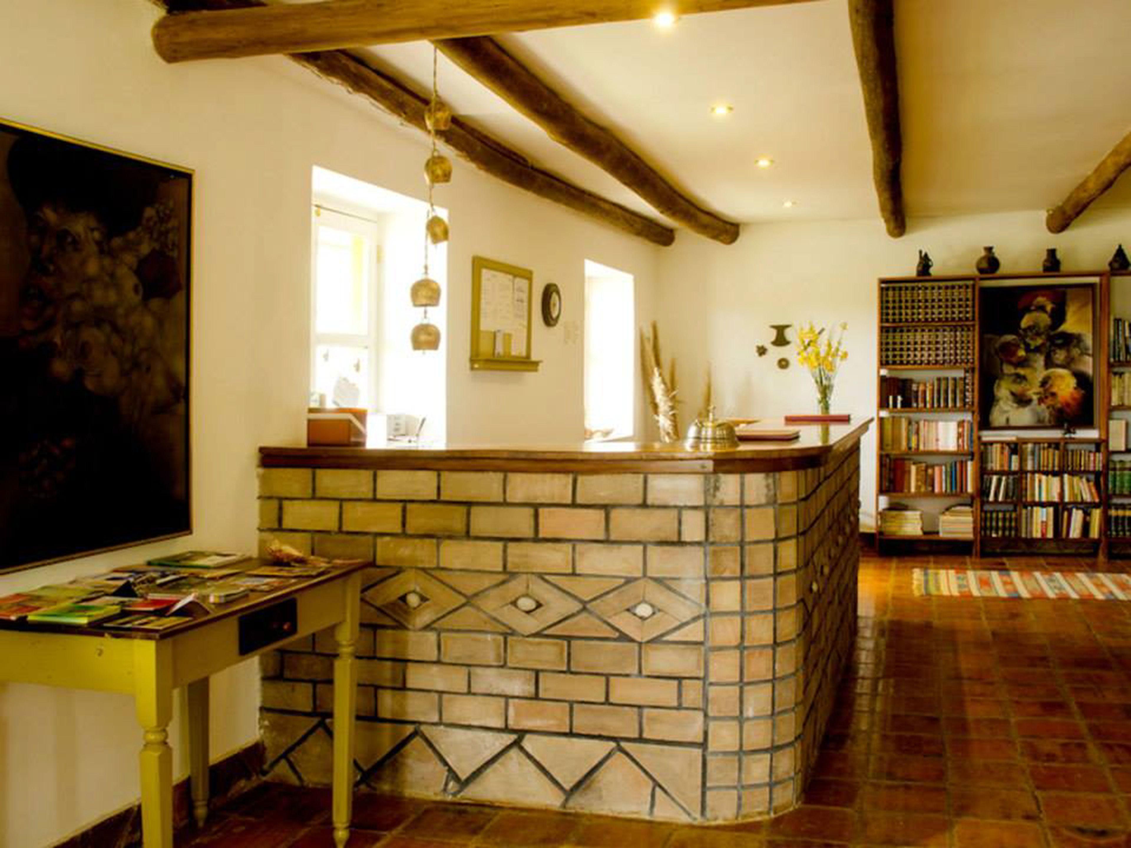 Una habitación acogedora con una barra de azulejos, una estantería y un cuadro en la pared.