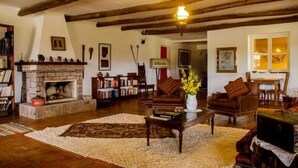 A cozy living room with a fireplace, bookshelves, a coffee table, and comfortable seating. - Tambo Sapalanchan Lodge (Lámud)