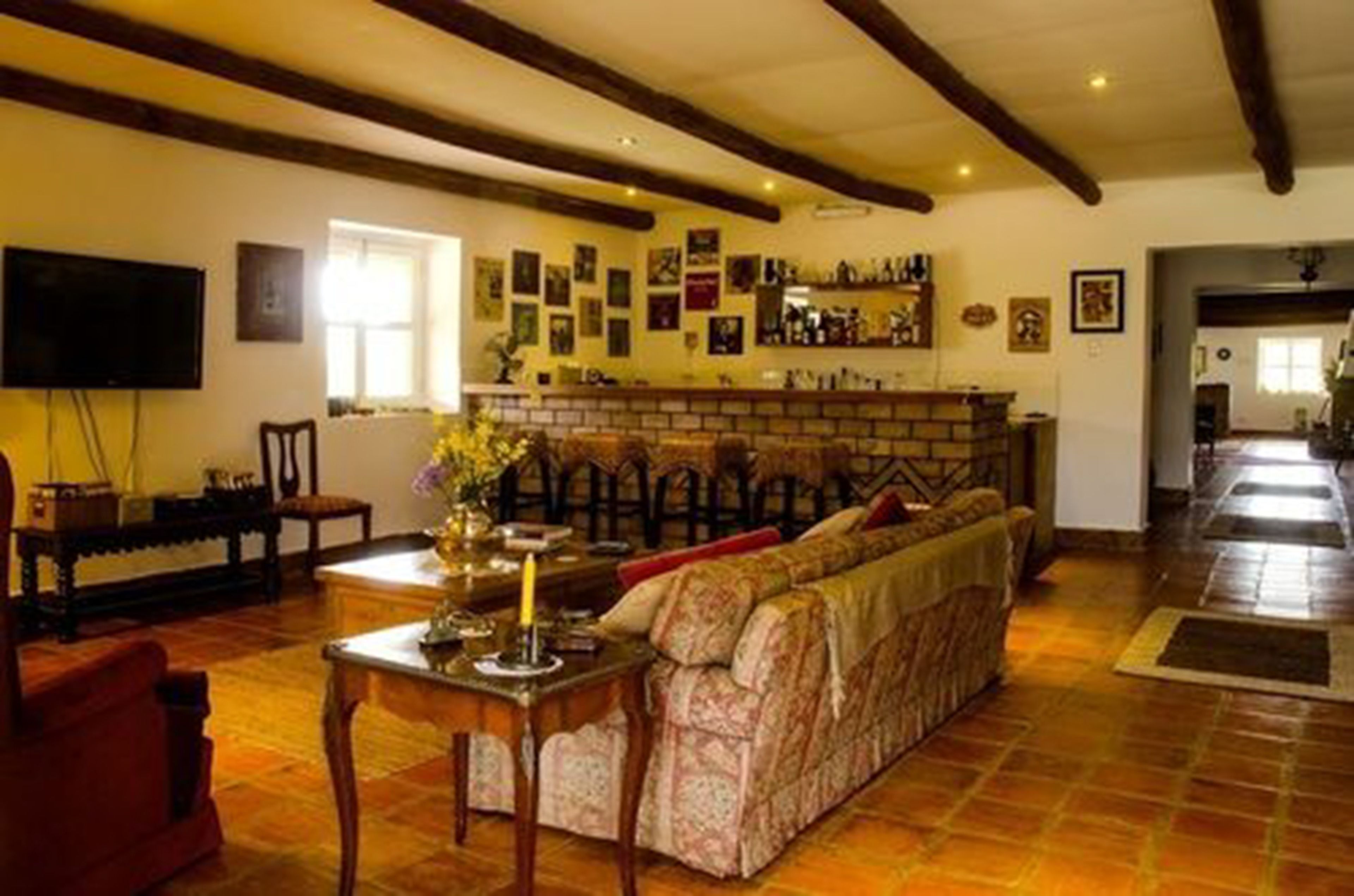 Un salón acogedor con un sofá, una mesa con una vela y una chimenea.