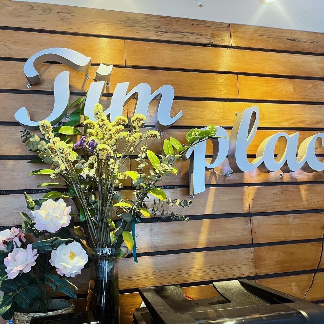 A wooden wall with the words "Jim Place" in large letters.