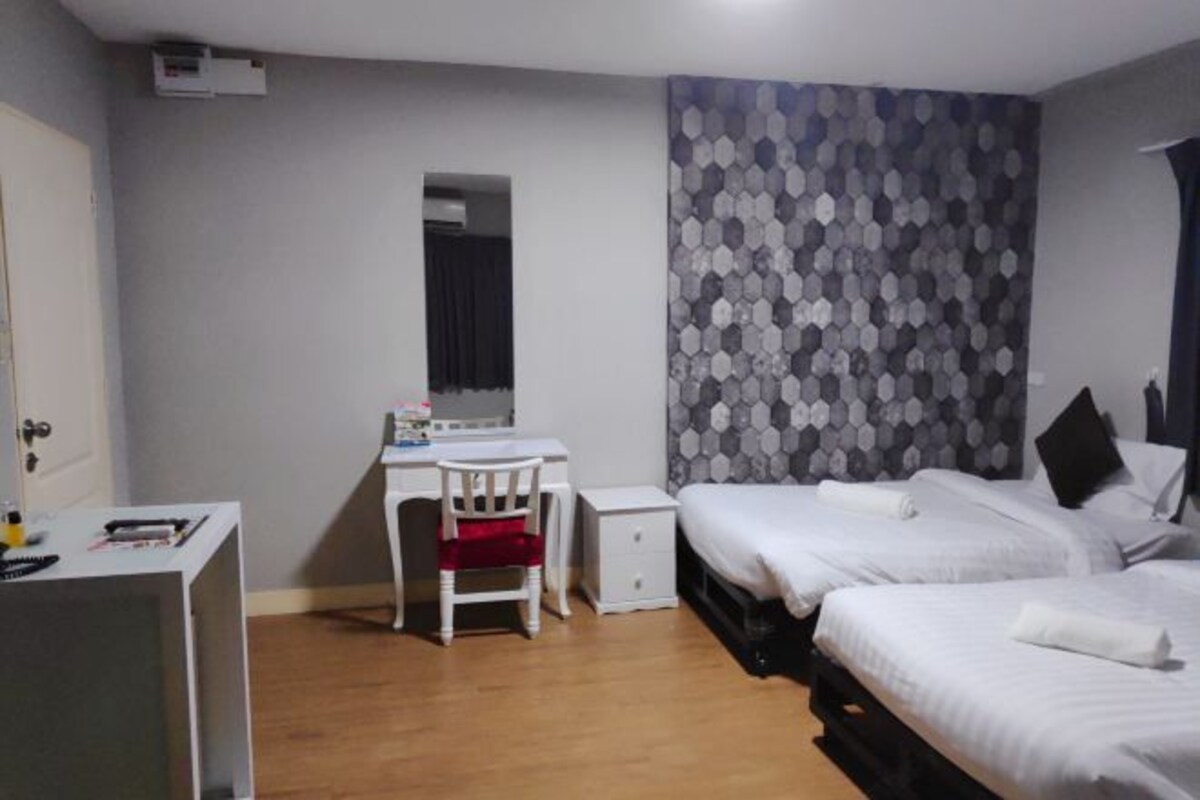 Un dormitorio con dos camas, un escritorio, una silla y un armario.