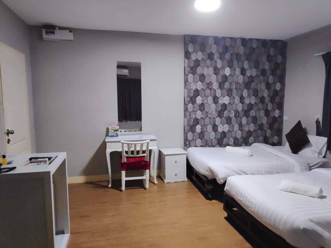 Habitación de hotel con una cama, un escritorio y una silla. Se ve un ventanal con vistas al exterior.