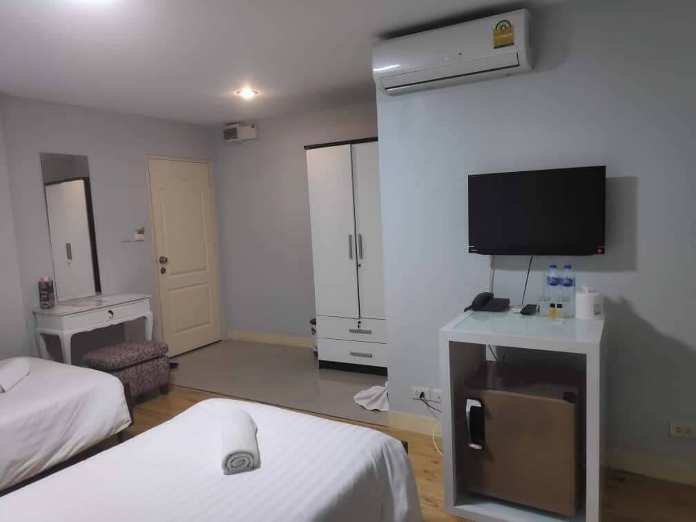 Une chambre d’hôtel avec deux lits, une télévision, une armoire et un appareil de climatisation.