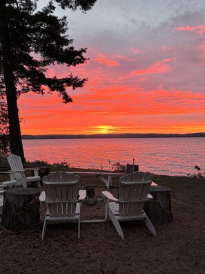 A sunset view with chairs and a fire pit by a lake. - Thanksgiving, Christmas, New Years available, room for family and friends🦃 ☃️🍾 (Elk Rapids)